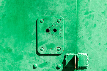 The keyhole in the metal garage door. Old iron doors of green color