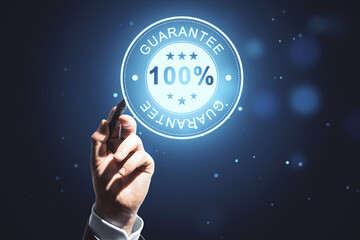 Close up of man hand pointing at glowing 100% guarantee stamp hologram on dark background with...