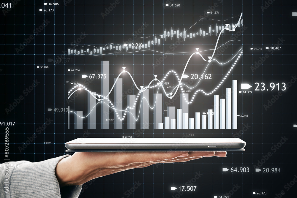 Poster close up of hand holding tablet with creative candlestick forex chart or graph on dark background. f