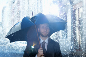 Frustrated businessman with broken umbrella in rain
