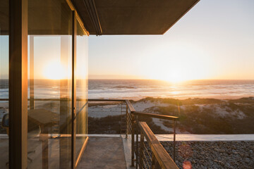 View of sunset over ocean from balcony of modern house