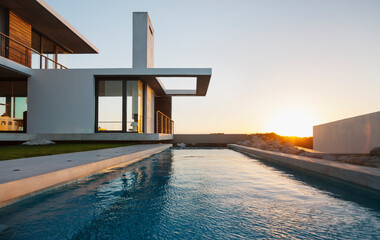 Lap pool outside modern house at sunset