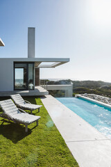 Lounge chairs and lap pool outside modern house