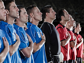 Soccer teams listening to anthem on field - obrazy, fototapety, plakaty