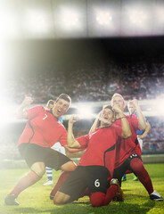 Obraz na płótnie Canvas Soccer team celebrating on field