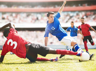 Soccer players kicking ball on field - obrazy, fototapety, plakaty