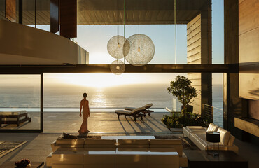 Woman in modern house overlooking ocean