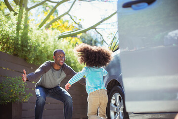 Enthusiastic father greeting daughter outside car