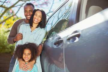 Portrait of happy family outside car