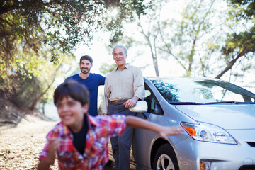 Multi-generation men outside car