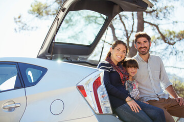 Portrait of happy family at back of car