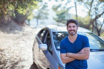 Portrait of smiling man leaning on car