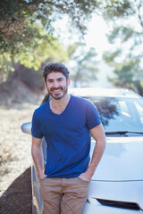 Portrait of smiling man leaning on car