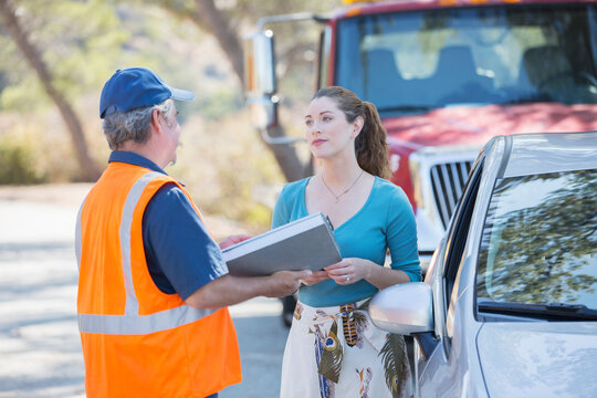 Roadside mechanic talking with woman