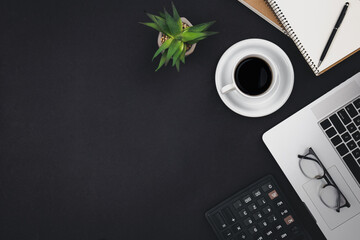 Laptop, coffee cups and notepads on a black background, top view.