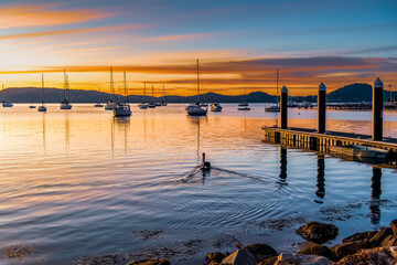Beautiful sunrise with high cloud and boats on the water