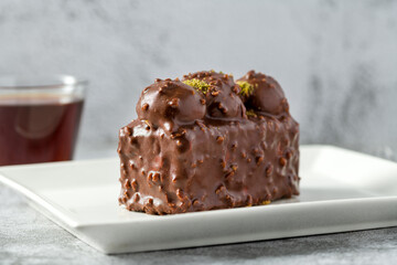 Cake with profiteroles with tea on stone table