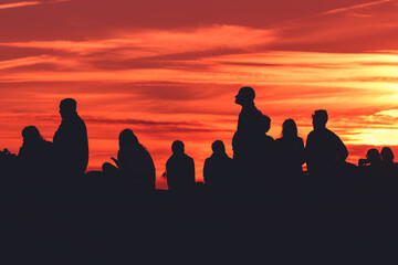Back lit group of people in silhouette enjoying amazing summer sunset