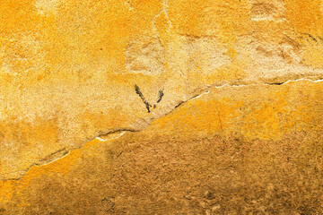 Damaged cracked yellow concrete wall as background and copy space