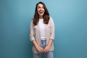 pretty 25 year old woman in a casual look smiles cutely on a blue background