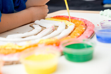 Kid at home makes and paints a rainbow. Exercise for Young artist. Early education, Montessori methodology. Implement to develop fine motoric skills. Zero waste, DIY games at home.
