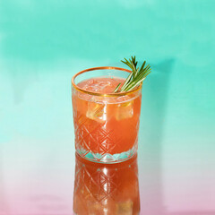 Summer creative layout with coctail glass on mirror reflection gradient pink green background. 80s or 90s retro aesthetic idea. Minimal summer coctail idea.