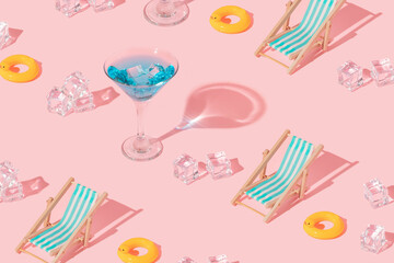 Summer creative pattern with martini coctail glass, duck swim ring, beach chair and ice cubes on...