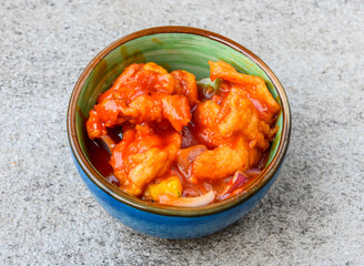 sweet and sour chicken served in bowl isolated on background top view of asian food