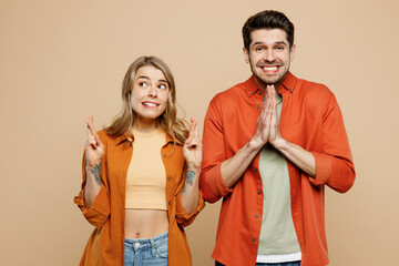 Young worried couple two friends family man woman wear casual clothes keeping fingers crossed hold...