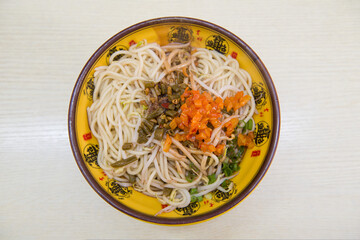 a bowl of hot dry noodles with sesame paste on table