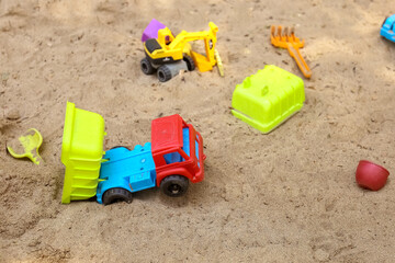 Fototapeta na wymiar Children's toys on the sand ,dump truck, backhoe