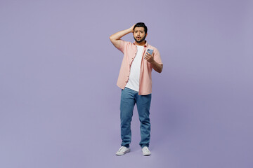 Full body sad shocked scared young Indian man wear pink shirt white t-shirt casual clothes use...