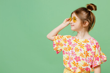 Little cute child kid girl 6-7 year old wear casual clothes sunglasses look aside on area have fun isolated on plain pastel green background studio portrait Mother's Day love family lifestyle concept
