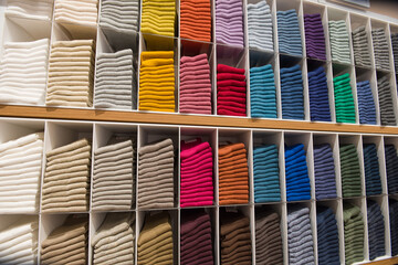 Stack of colorful folded socks fabric on store shelf.