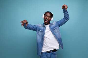 cool dude american man with dreadlocks in a denim jacket relaxes to music in headphones