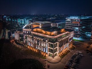 Budapest, Hungary - Aerial view of the beautiful illuminated National Theater of Hungary at dusk with clear dark blue sky and business district at background