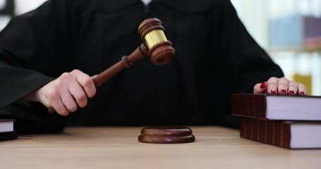 Judge in robe knocks wooden gavel in courtroom. Judge deciding in law