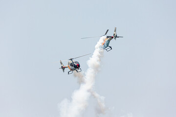 Pilot copter team doing aerial tricks with steam at Gijon Air Show Festival