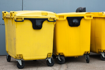 yellow garbage containers on a gray background close-up