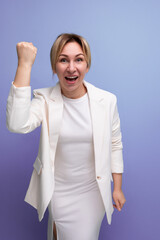 young joyful well-groomed blond boss woman in a white jacket and dress