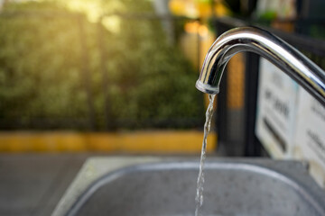 Water running from a tap. water drop dripping from the tap and water shortage. Global warming has caused drought. Climate change, global warming concept. Accidents and Disasters