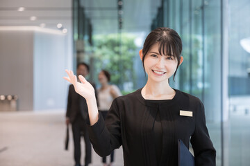 For images of travel, etc. A woman giving directions at a reception desk, concierge, hotel front...