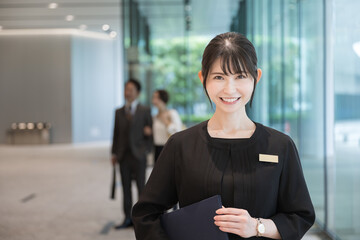 Image of a woman giving directions at a reception desk, concierge, hotel front desk, etc.