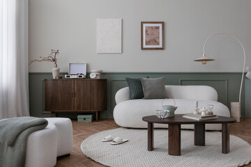 Warm and cozy living room interior with mock up poster frame, boucle sofa, wooden sideboard, coffee table, stylish lamp, gramophone, vase with leaves and personal accessories. Home decor. Template.