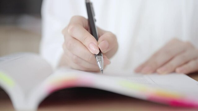 テキストを使って勉強する女性の手元
