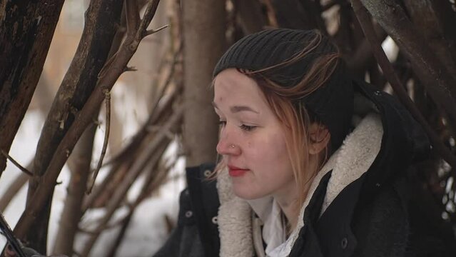 homeless woman paints her lips with red lipstick. a woman kisses a mirror.a homeless woman in the forest. slow motion video. High-quality shooting in Full HD