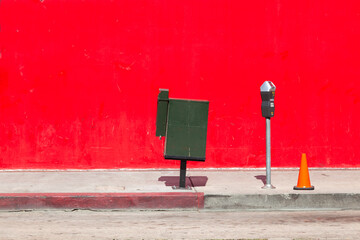 parking meter in front of red wall