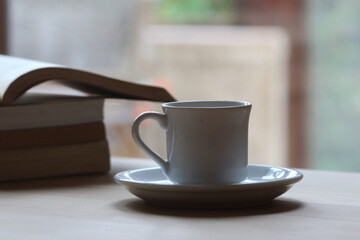 Cup of coffee on the table. Reading a book concept. 