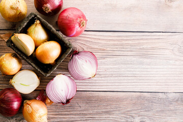 Fototapeta na wymiar colorful onions on rustic wooden background.