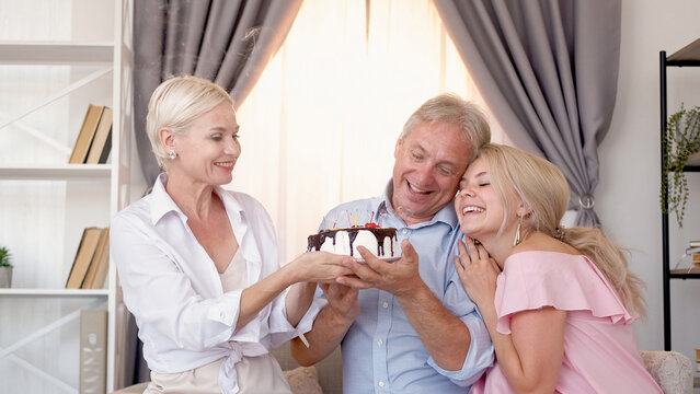 Birthday Greeting. Family Celebration. Holiday Cake. Excited Man Woman And Daughter Holding Festive Pastry In Light Home Interior.